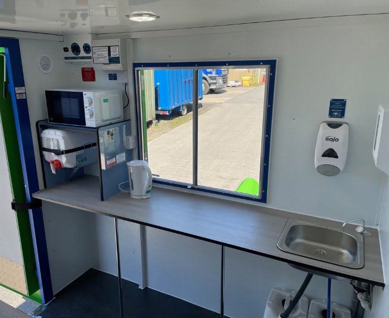 The interior of Philspace's eco-6 welfare unit showing a water tank, sink, and microwave