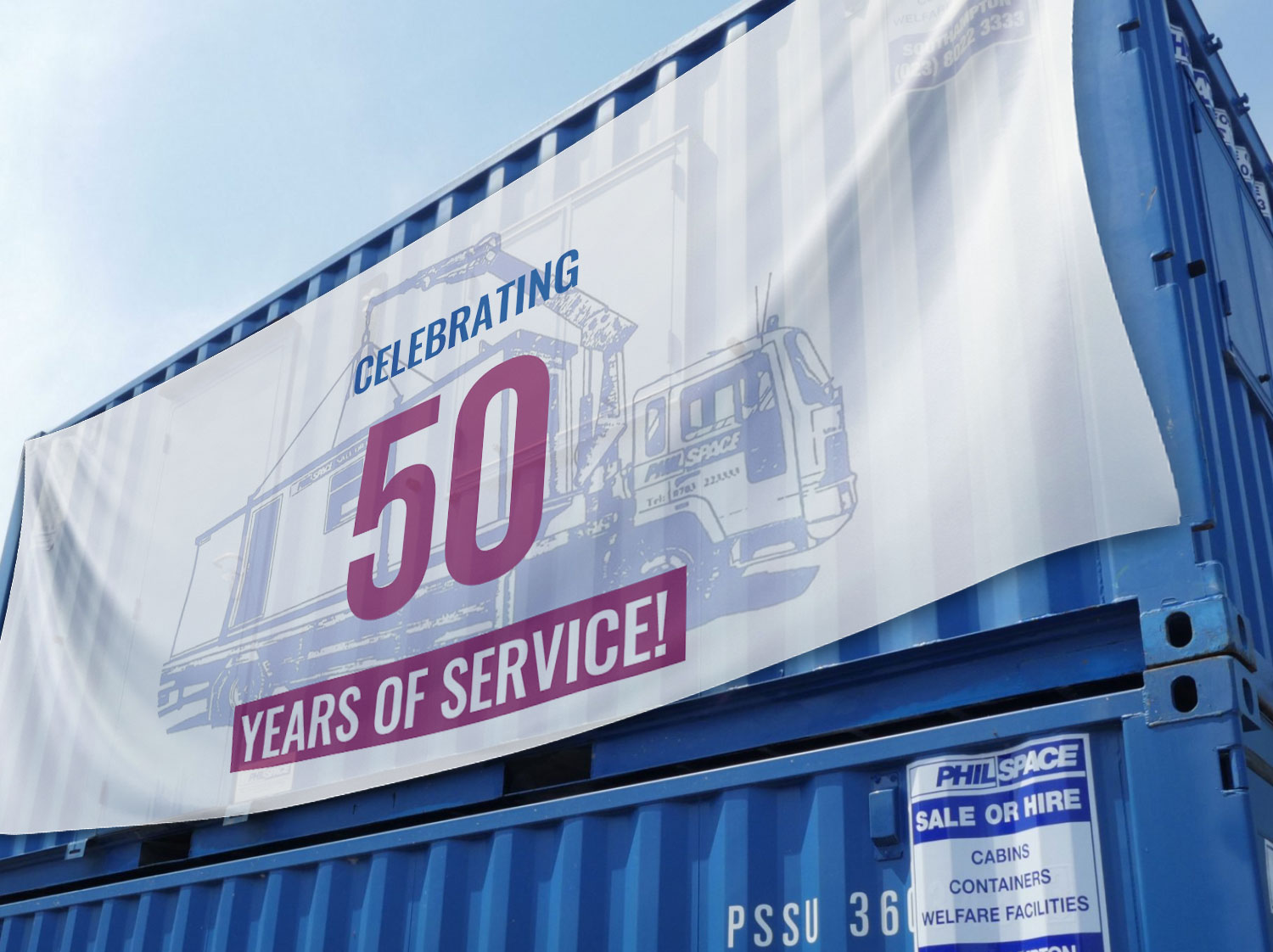 A philspace 50 years of service banner hanging over a blue shipping container